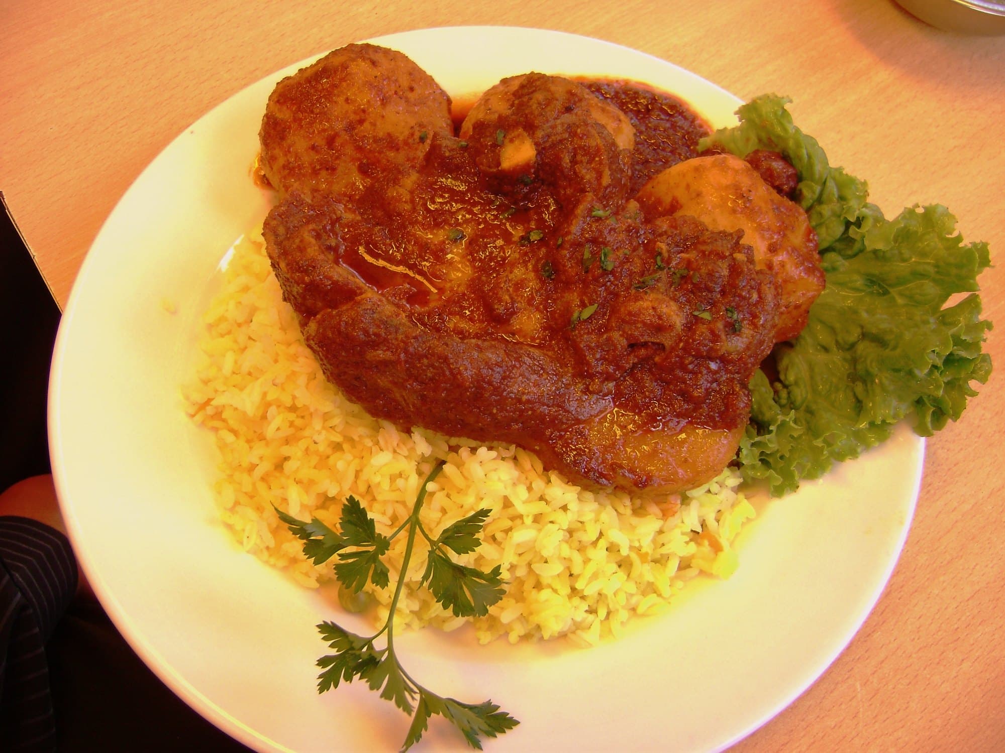 Presas de chancho bañadas en salsa de ají colorado sobre arroz, servidas en Huancayo